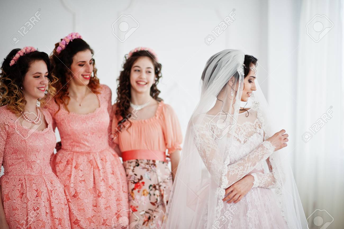 Fantastic bride posing in wedding dress with helpful pretty brid